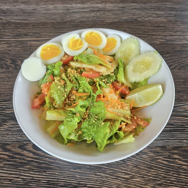 Soi21 Asian Bistro & Bar's fresh salad with lettuce, tomatoes, peanuts, boiled eggs, cucumber, and lime.
